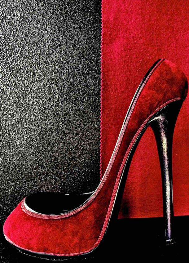 Photographie d'exposition 2025 : escarpin rouge à talon aiguille sur fond bicolore noir et rouge, esthétique glamour.