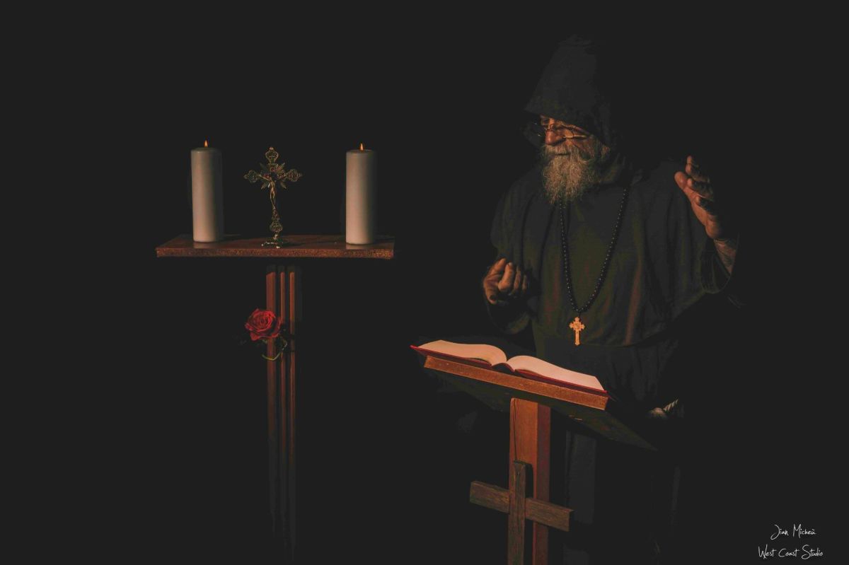 Photographie d'exposition 2025 : moine ou religieux barbu en robe de bure lisant un livre ancien, ambiance mystique et cinématographique.